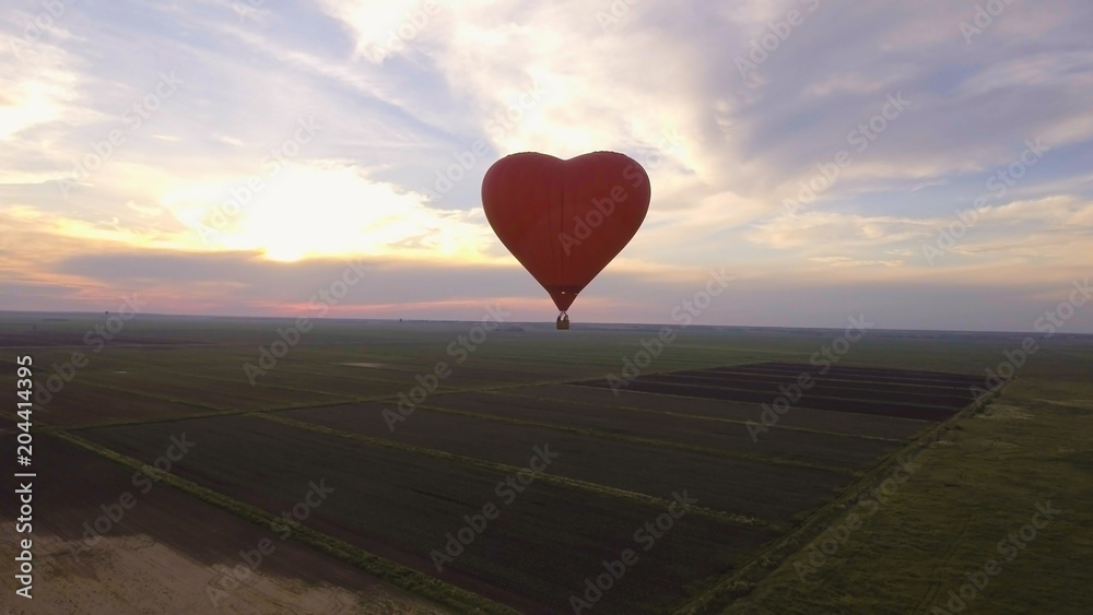 Fototapeta premium Hot air balloon shape of a heart in the blue sky. Aerostat, Airship. Red balloon.