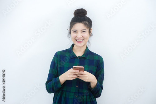 Asian beautiful girl happy smile in room and use mobile phone with copy space