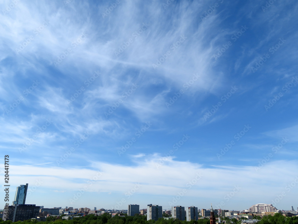 Clouds in the blue sky above the city. Summer panorama of Moscow, urban background