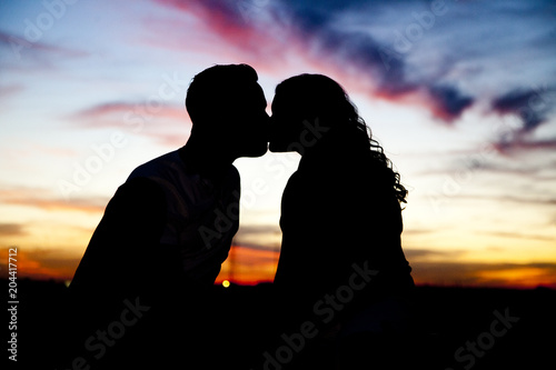 Silhouette of Couple Kissing at Sunset © Katy