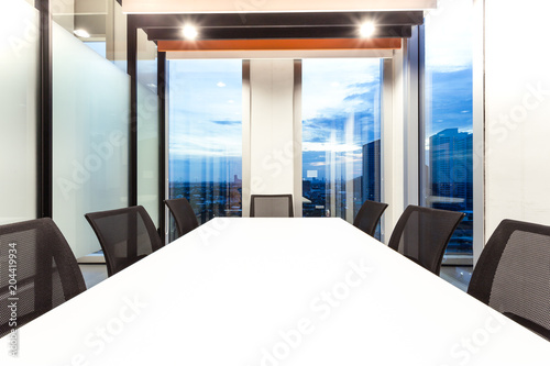 Modern meeting room with for present, large windows outside building with blue sky and clouds, twilight sky, city, tower view, soft focus