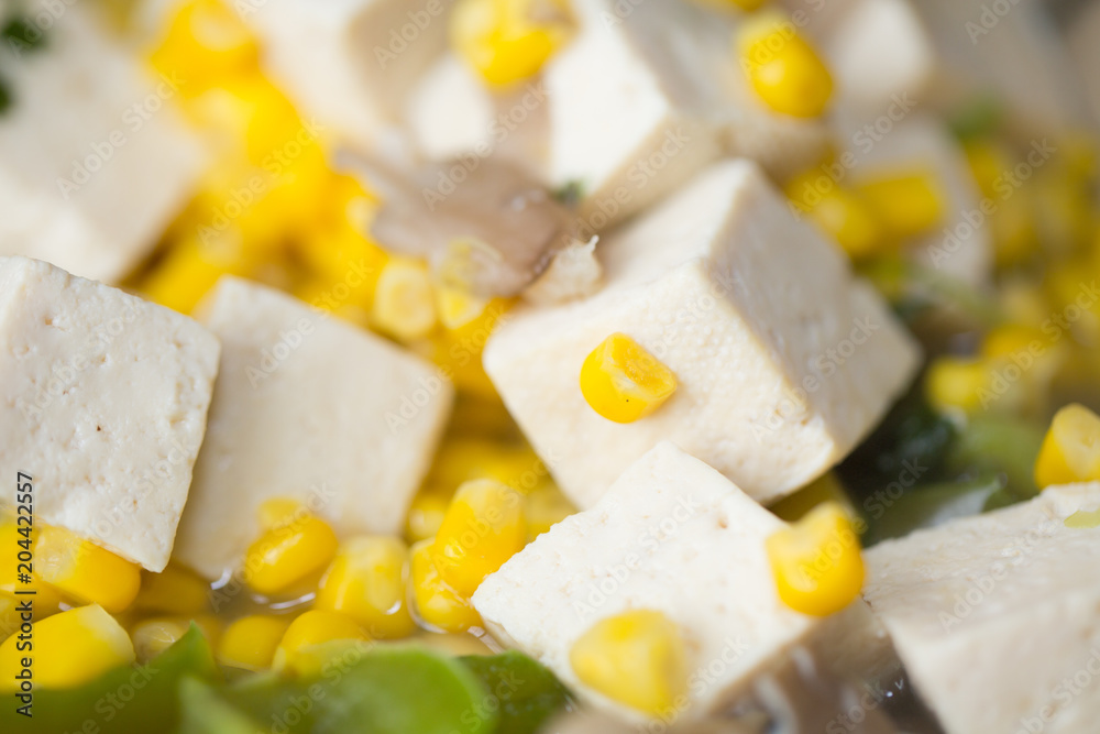 close up corn and tofu soup.