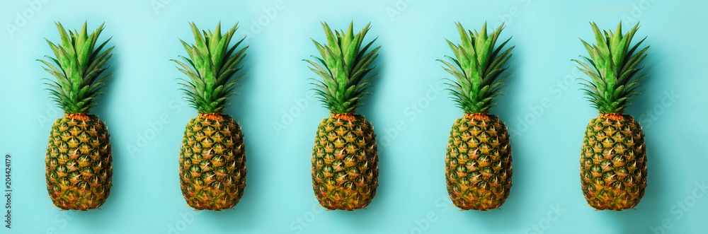 Bright pineapple pattern for minimal style. Top View. Pop art design, creative concept. Copy Space. Fresh pineapples on blue background.