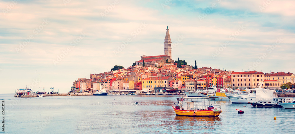 Beautiful city landscape with sea boats, colorful houses and an ancient tower in Rovinj, Croatia, Europe in pastel colors (vacation, rest - concept)