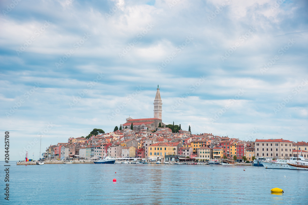 Beautiful city landscape with sea boats, colorful houses and an ancient tower in Rovinj, Croatia, Europe. (vacation, rest - concept)