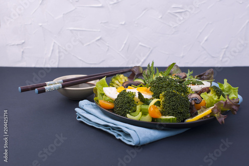  90/5000 Ovoshchnoy salat s yaytsami i brokkoli i kitayskiye palochki. Vostochnaya yeda. Zdorovyy obed. Tekst Vegetable salad with eggs and broccoli and Chinese sticks. Eastern food. Healthy lunch. Te photo