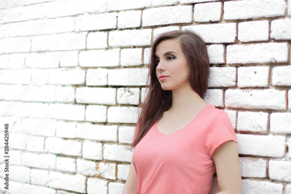 young beautiful girl near white brick wall, street style, place for text