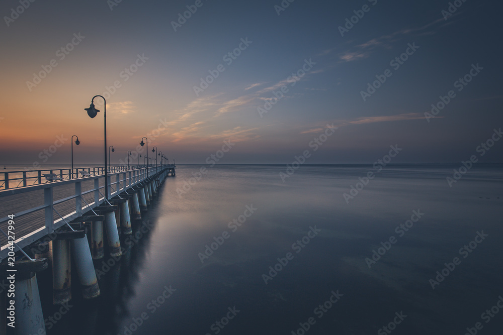 Amazing colorful sunrise over the pier in Gdynia Orlowo. Sunrise over the sea.