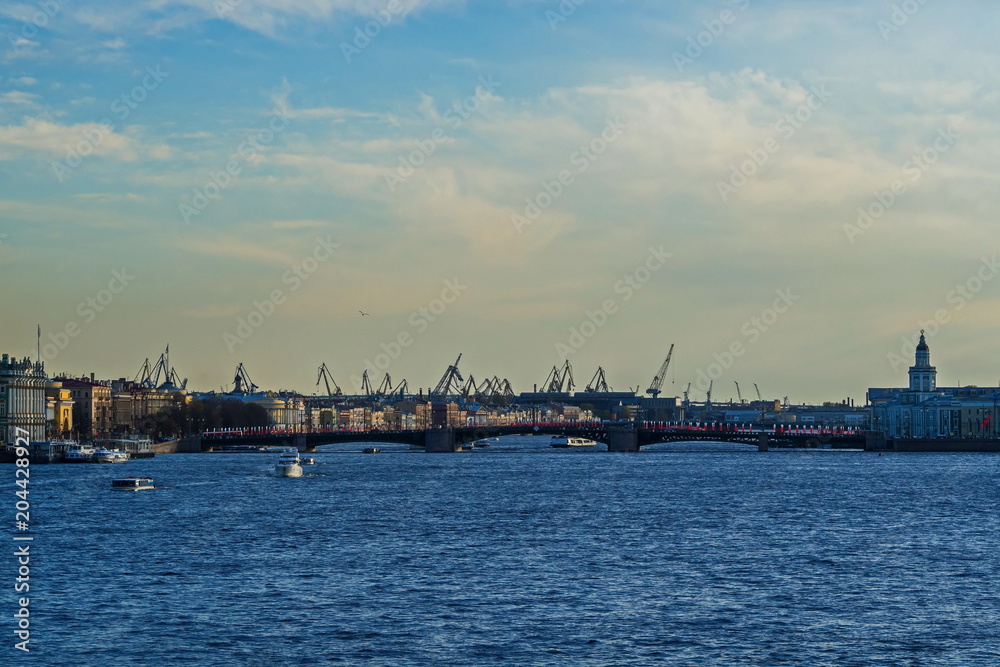 View of the Neva river, Palace bridge and port cranes of St. Petersburg.