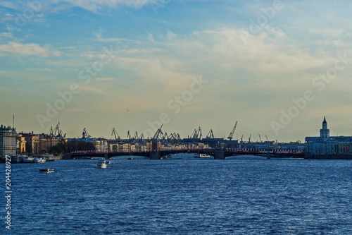 View of the Neva river, Palace bridge and port cranes of St. Petersburg.