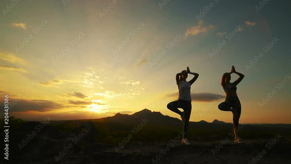 a group of girls doing yoga at sunset in the mountains. Slow motion a group of girls doing yoga at sunset in the mountains. Slow motion
