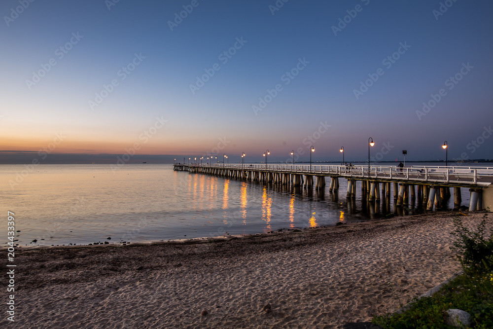 Amazing sunrise on the pier at the seaside. Gdynia Orlowo, Poland