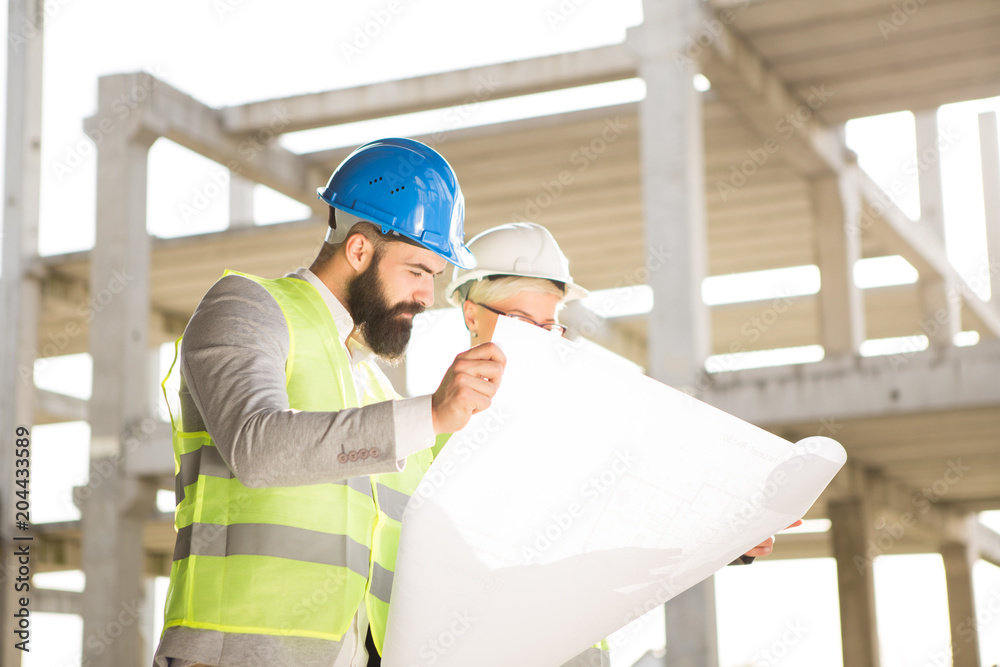 Hipster engineer and his colleagues on the construction site. Hipster engineer and his colleagues on the construction site.