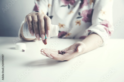 woman pours out pills from a bottle