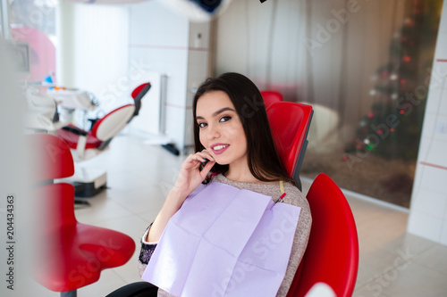 Beautiful girl laughs in the dental chair. photo