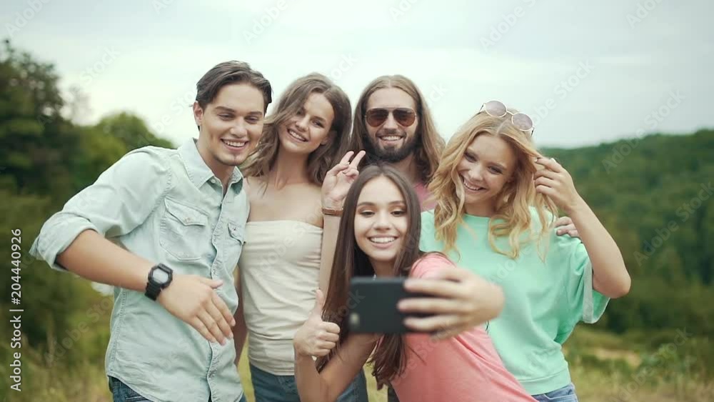 Smiling Young Men And Women Taking Photos In Nature Smiling Young Men And Women Taking Photos In Nature