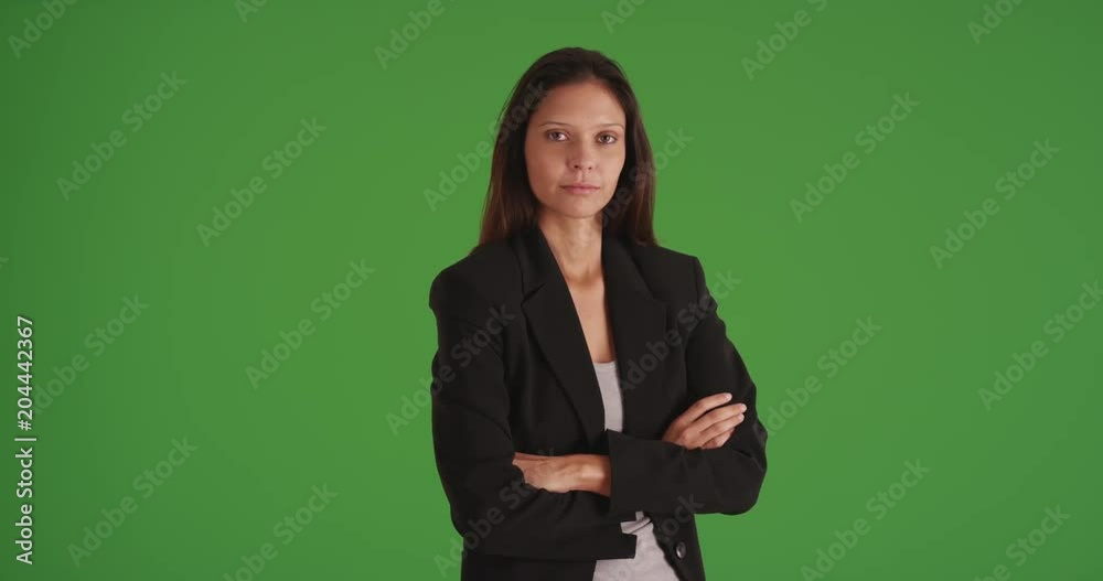 Serious business woman with arms crossed looking at camera on green screen Serious business woman with arms crossed looking at camera on green screen