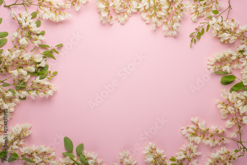 Spring floral background, textures and wallpaper. Flat white flower flowers on a light pink background, top view, copy space. Festive greeting card for women or wedding invitation