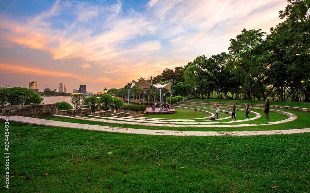 Fototapeta premium Evening at the park in the heart of Bangkok. People have to sit and exercise for good physical health. And fresh air (Benjakitti Park)