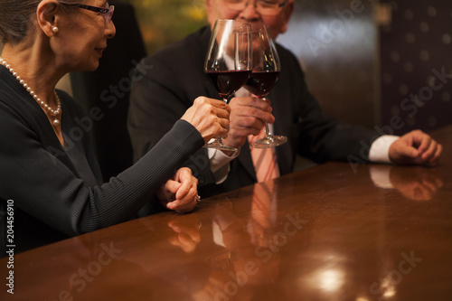 ワインで乾杯。グラスを合わせる老夫婦。