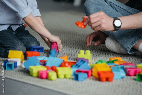 partial view of family playing with colorful blocks together at home