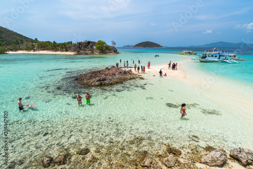 Coron, Philippines - March 28, 2018: Tropical beach with tourists and boats on the Bulog Dos island, Palawan, Philippines
