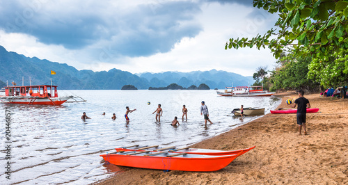 BUSUANGA PHILIPPINES - MARCH 29, 2018 : View of playing children at Busuanga against of Coron island, Palawan Philippines