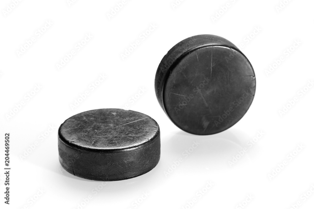 Obraz premium Two hockey pucks on a white background