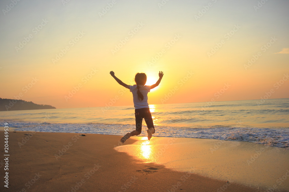 flying jump beach child girl on the beach in summer holiday, on sunset time.Happy little girl on the beach.soft focus