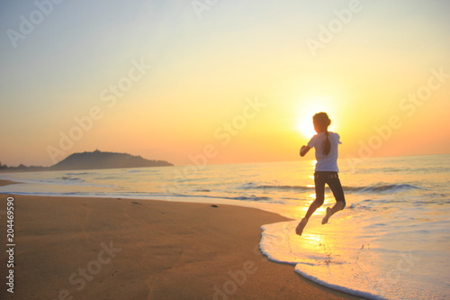Fototapeta Naklejka Na Ścianę i Meble -  flying jump beach child girl on the beach in summer holiday, on sunset time.Happy little girl on the beach.soft focus