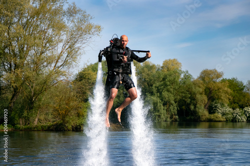 Thrillseeker, man, athlete strapped to Jet Lev, levitation soars into a blue sky with wispy clouds photo