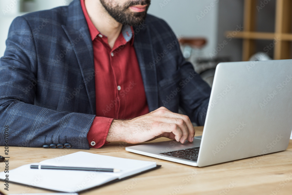 cropped shot of businessman working with laptop at office