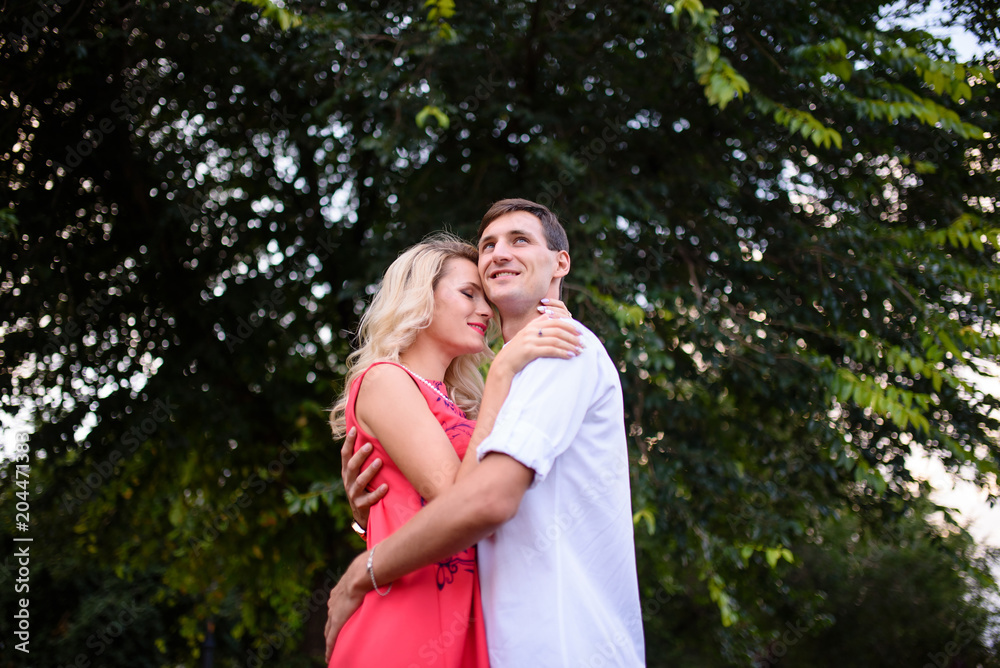 A man and woman in love walk in the park and hug. A man and woman in love walk in the park and hug.