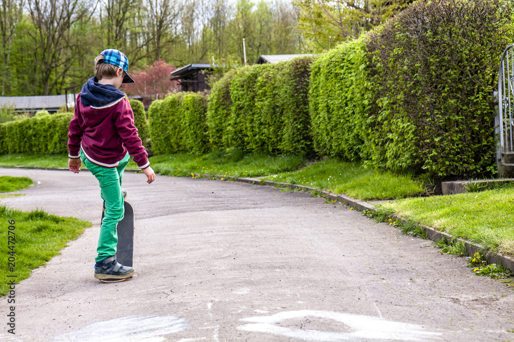 Fototapeta premium Little urban boy practicing with skateboard.