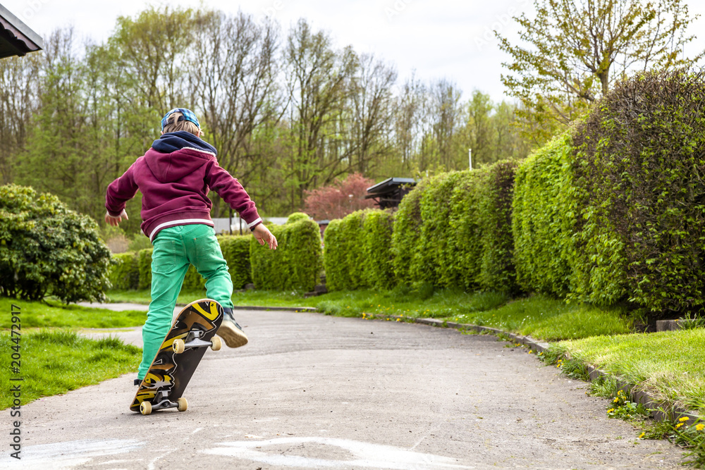 Fototapeta premium Little urban boy practicing with skateboard.
