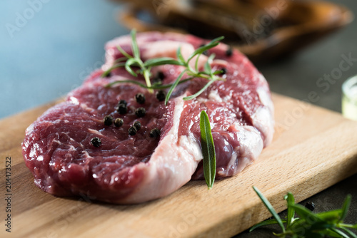 Fresh raw Prime Black Angus beef steaks on wooden board: