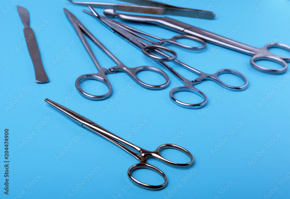 surgical instruments and tools including scalpels, forceps and tweezers arranged on a table for a surgery. surgical instruments and tools including scalpels, forceps and tweezers arranged on a table for a surgery.
