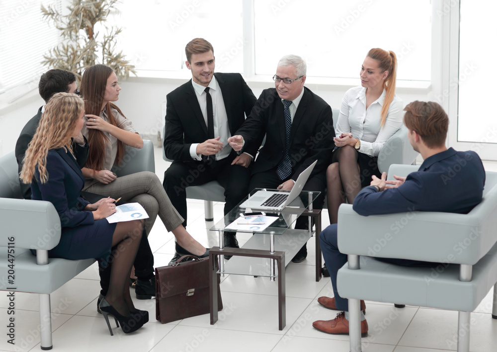 senior businessman and business team sitting in the lobby of the modern office. senior businessman and business team sitting in the lobby of the modern office.