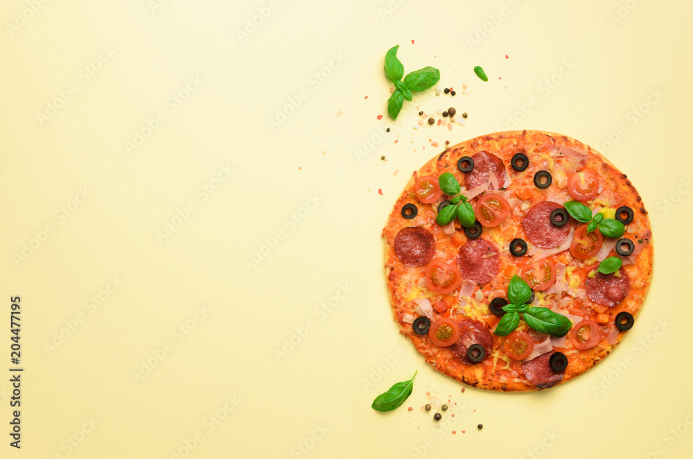 Fototapeta Delicious italian pizza, basil leaves, salt, pepper on yellow background with copyspace. Top view. Banner. Pattern for minimal style. Pop art design, creative concept