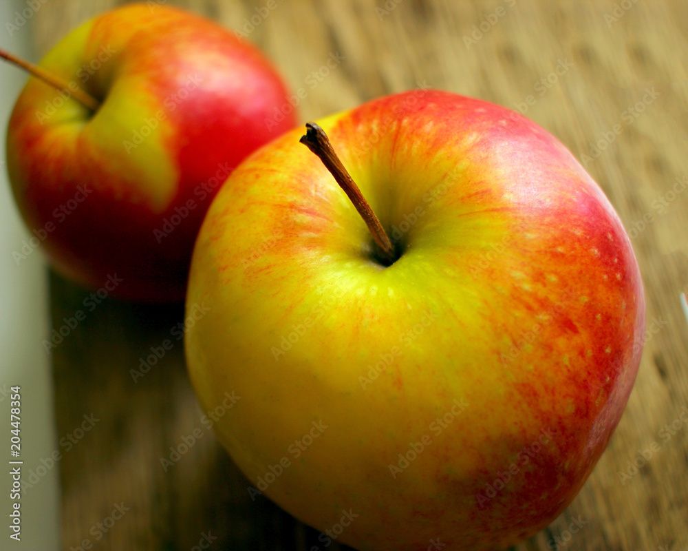 two juicy ripe apples on the background of an old wooden table close-up two juicy ripe apples on the background of an old wooden table close-up