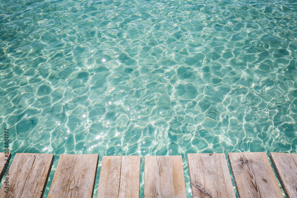 Background of wooden deck and blue water see. Mallorca, Spain. Top view. 