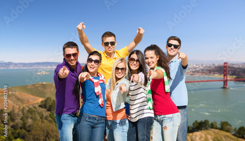 travel, tourism and people concept - group of happy friends pointing at you over golden gate bridge in san francisco bay background