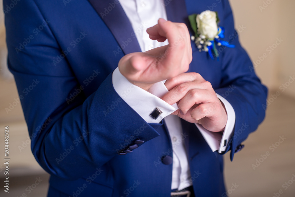 the groom is dressed in a blue suit and zap up on a white shirt