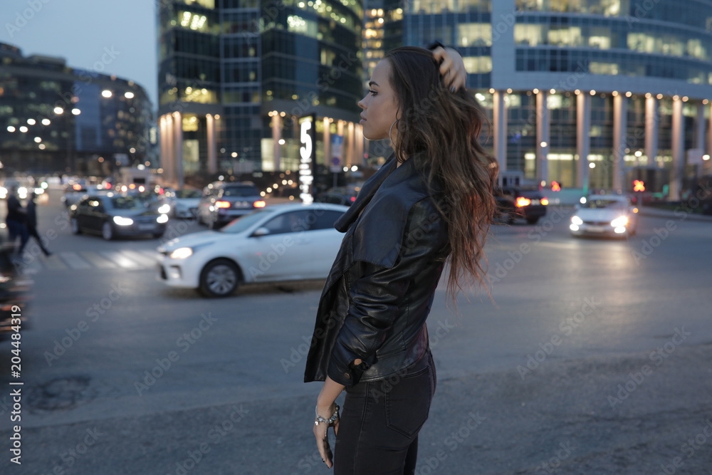Beautiful woman on a background of a night city and passing cars. Beautiful woman on a background of a night city and passing cars.