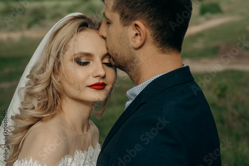 Newlyweds couple in love. Romantic wedding moment, relationships. Bride and groom kisses tenderly, beautiful pictures. guys enjoy. Sexy kissing stylish couple of lovers close up portrait.