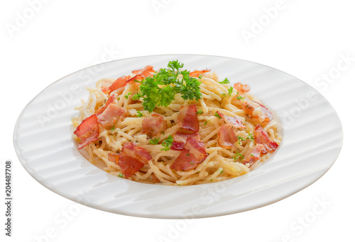Spaghetti carbonara with bacon, cheese and chopped parsley on wood table in side view copy space on white isolated background with clipping paths. Italian traditional homemade food so delicious.