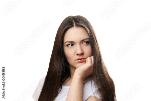 beautiful young woman on a white background, serious look, thinks, meditates