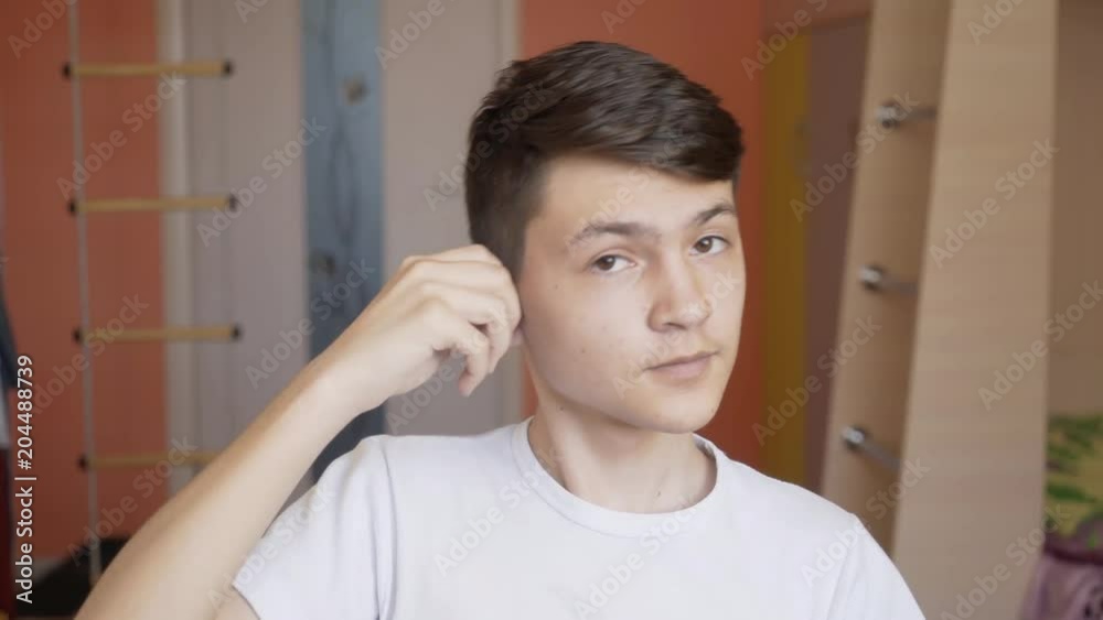 the young man wears a hearing aid. Man with hearing aid the young man wears a hearing aid. Man with hearing aid