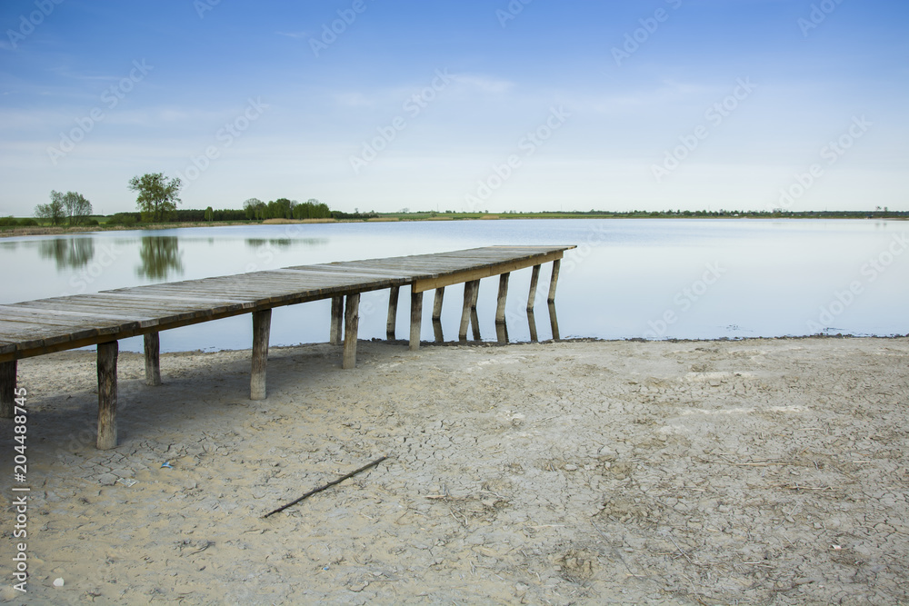 Wooden bridge and dry shore of the lake