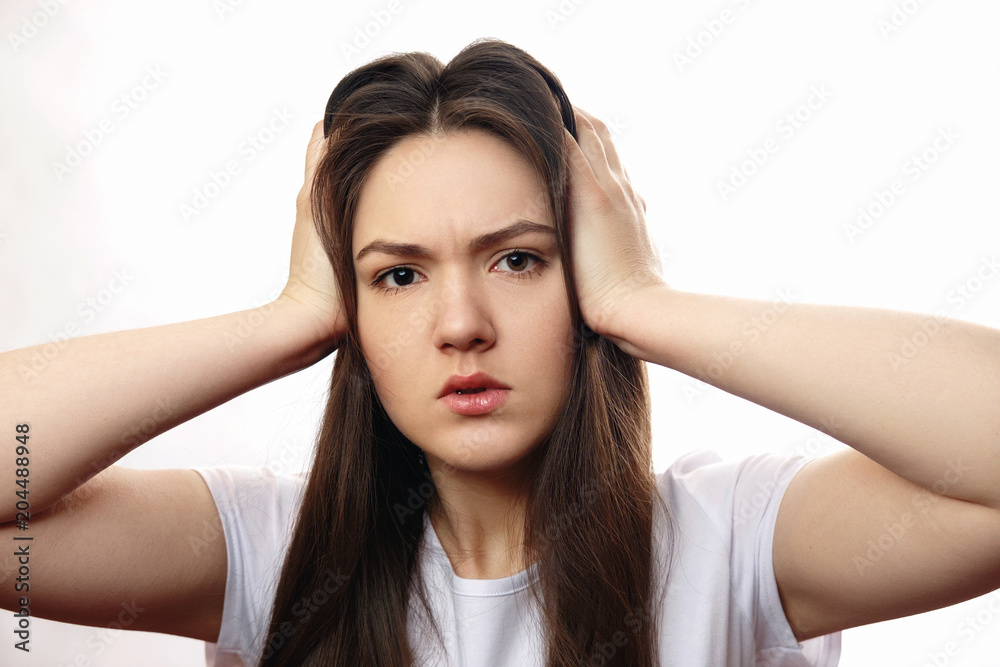 girl covers her ears with her hands, headache